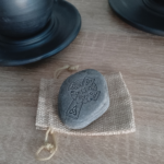 Engraved Celtic Cross and Claddagh stone placed on a rustic burlap pouch, ideal for gifting.
