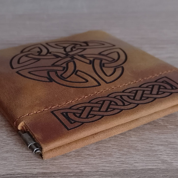 Close-up of the leather pouch, highlighting the engraving and stitching
