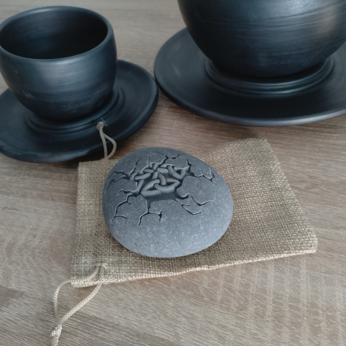 Engraved Celtic knot cracked stone displayed on a rustic burlap pouch, ideal for gifting.