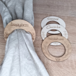 Personalised wedding place cards - Set of wooden napkin rings with personalised names and various graphic designs.