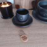 Round wooden keychain with engraved logo on table