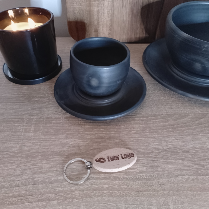 Oval wooden keychain with engraved logo on table