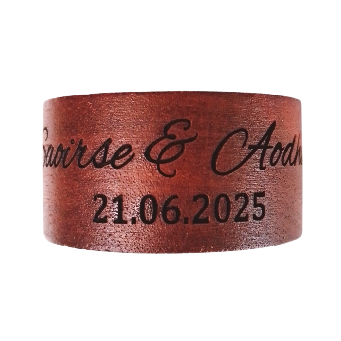 A wedding couple holding engraved napkin rings with their names and wedding date.