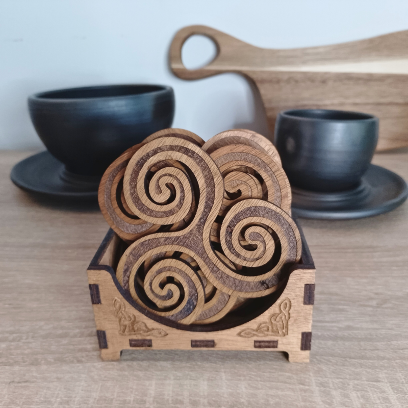 Set of 6 Triskelion wooden coasters in a Celtic-inspired storage box, displayed with ceramic cups.