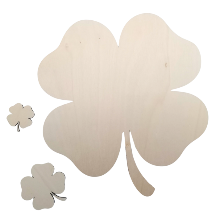 Close-up of various laser-cut plywood shamrocks on a transparent background