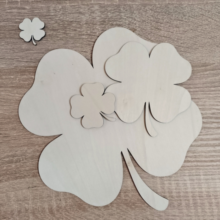 Multiple sizes of plywood shamrocks arranged on a wooden surface
