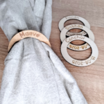 Set of four wooden napkin rings, engraved with names and dates.