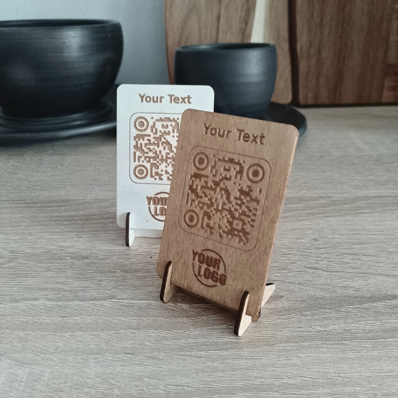 Two wooden QR code signs in different colours placed on a wooden surface.