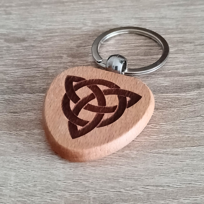 Wooden keychain with Celtic Triquetra engraving placed on a wooden surface