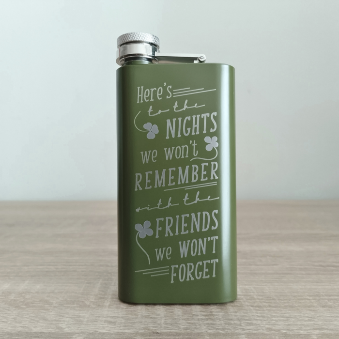 Army Green custom flask with humorous engraved Irish toast standing on wooden table.